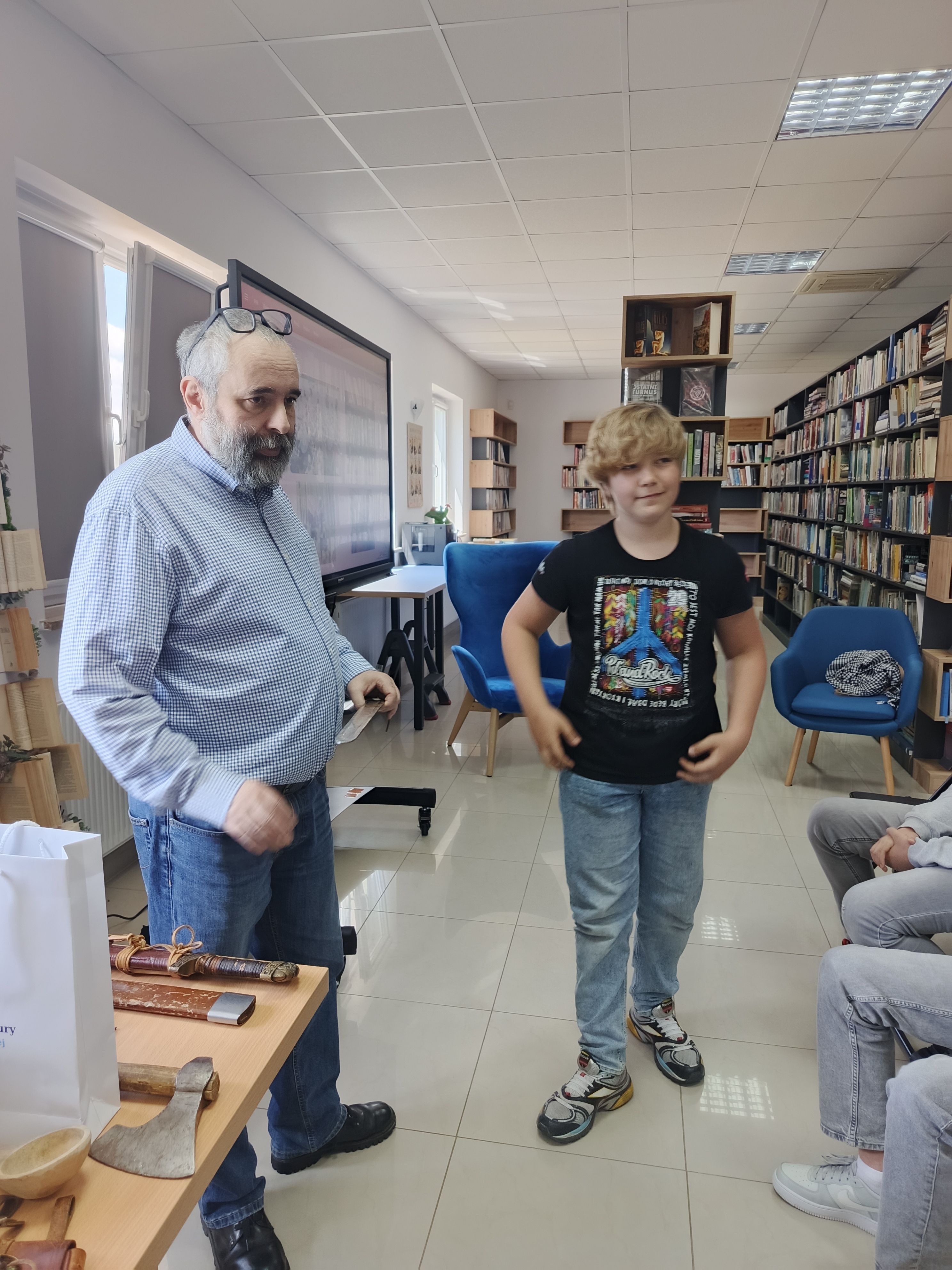 Autor książek wraz z uczniem biorącym udział w spotkaniu